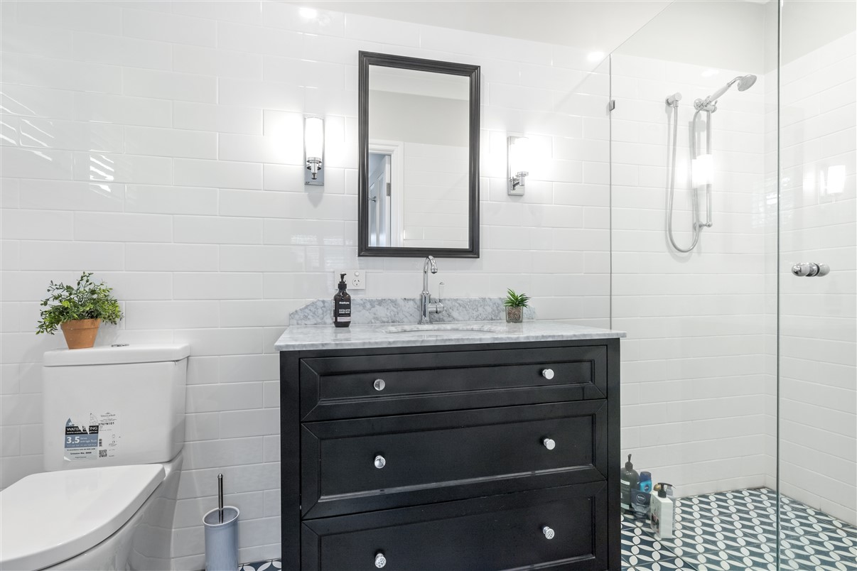 An elegant bathroom with a black timber vanity