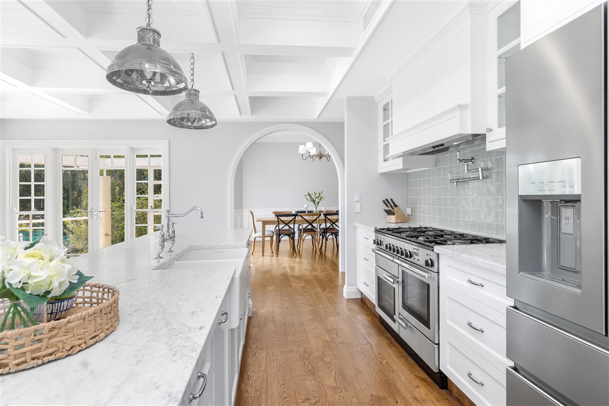 A kitchen opening through an archway to a dining room